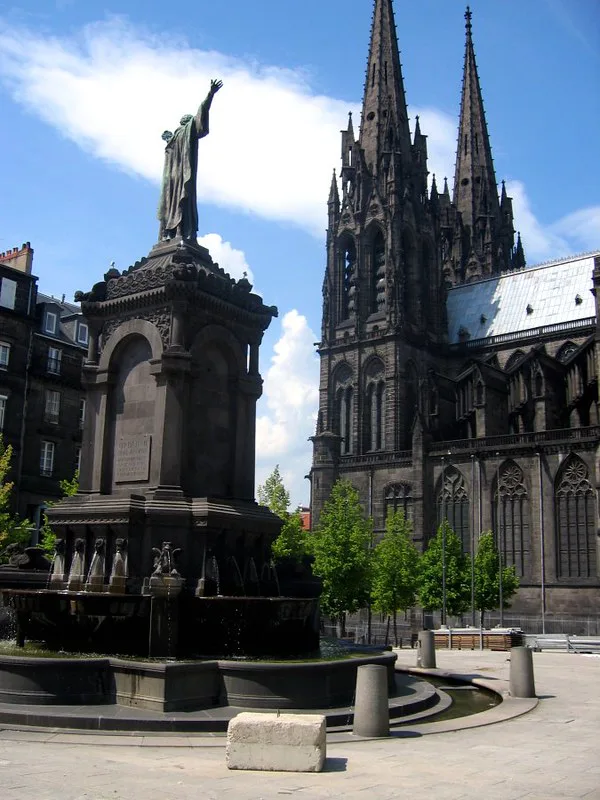 The dark volcanic-stone spires of Clermont-Ferrand Cathedral near a central Tram Line A stop