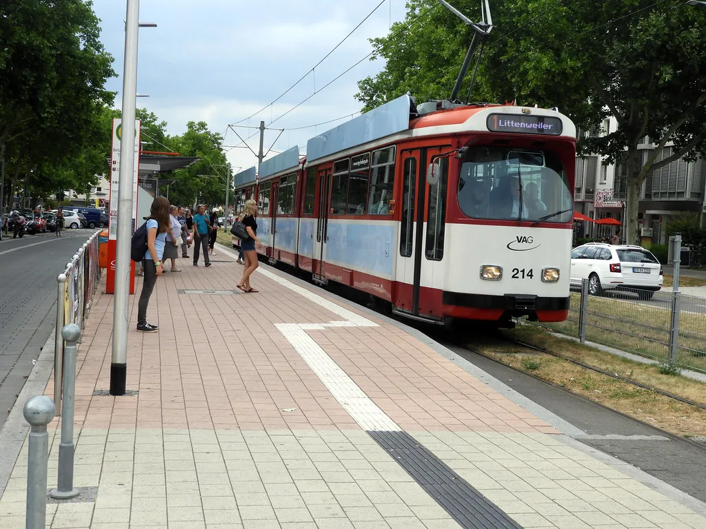 A green VAG tram travelling along Sundgauallee in Freiburg