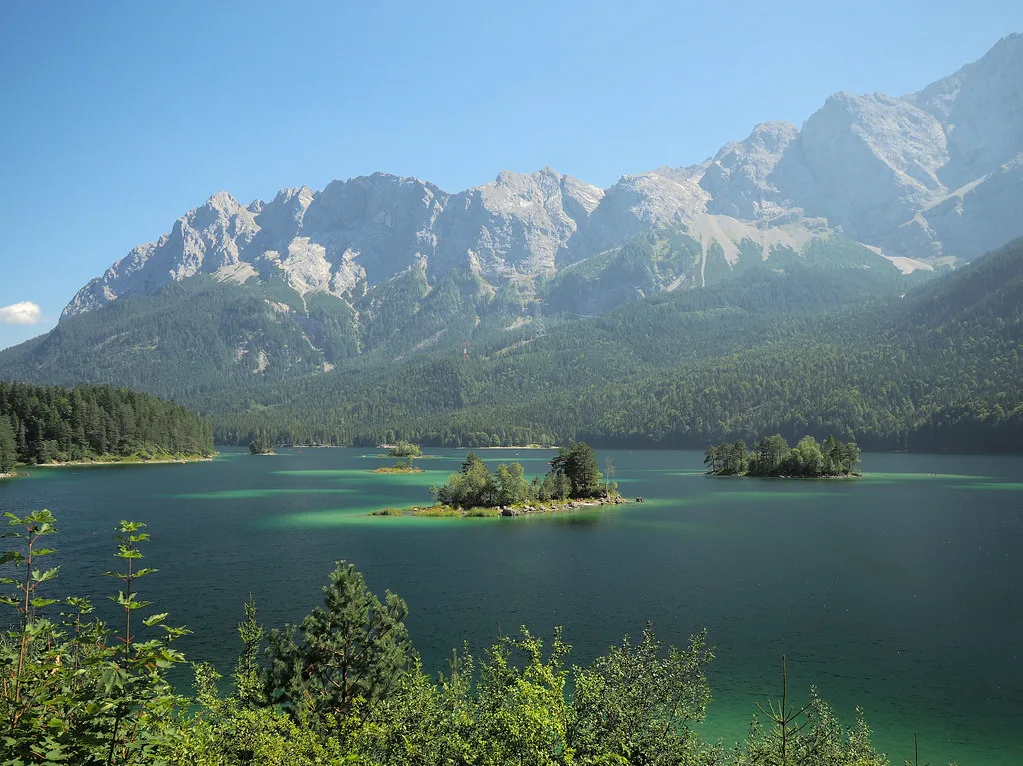 Turquoise waters of the Eibsee lake ringed by forest below the Zugspitze near Garmisch
