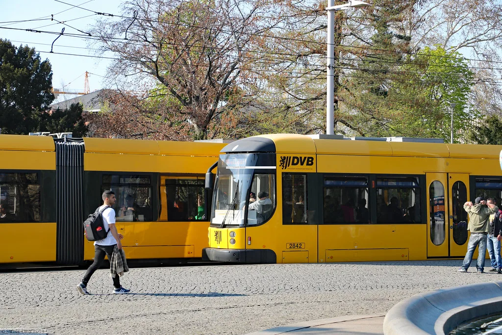 A bright yellow DVB tram on a street in central Dresden