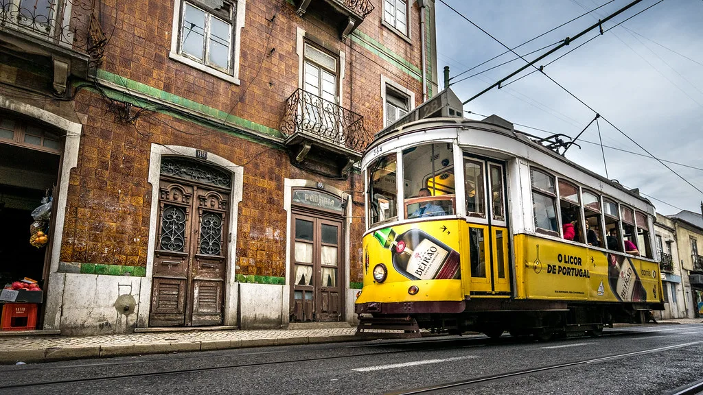The iconic yellow Remodelado Tram 28 on a Lisbon street