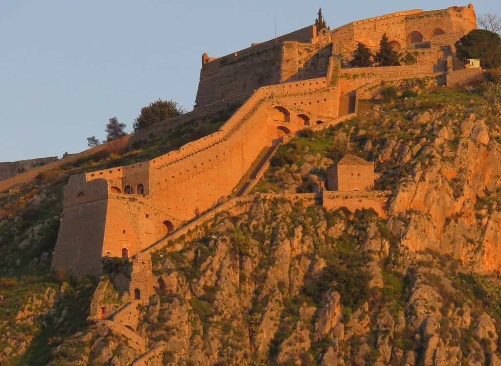 The cliffside Akronafplia fortress walls above Nafplio Old Town, reached by a steep narrow access road