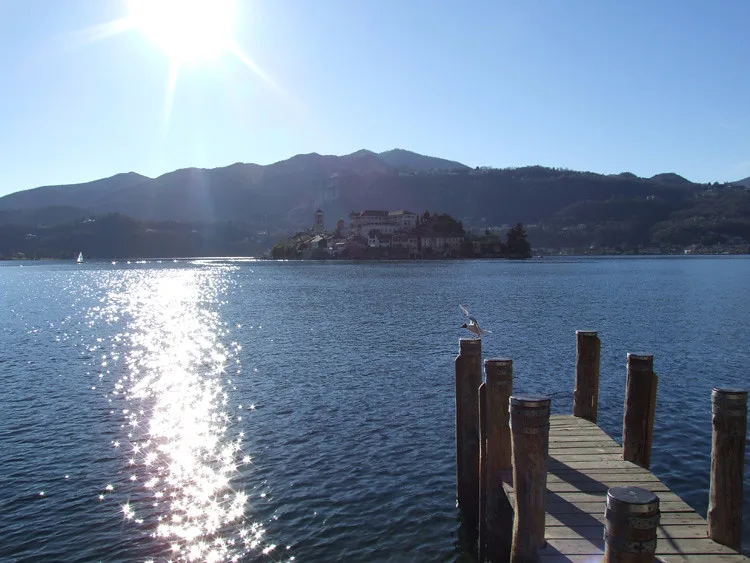 A boat crossing the calm waters of Lake Orta in Piedmont, Italy