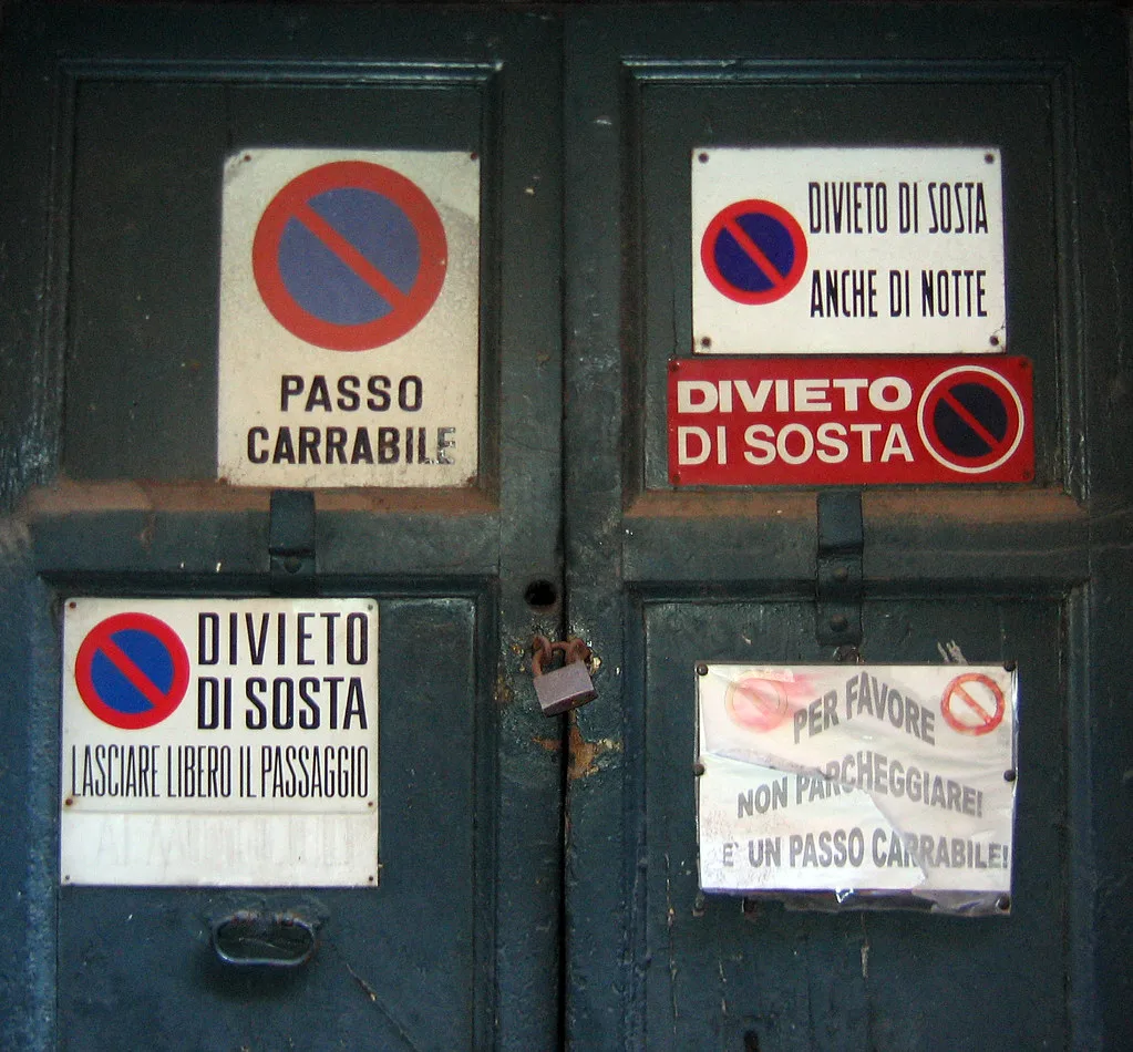 A no-parking street sign in a European city marking a restricted curbside zone