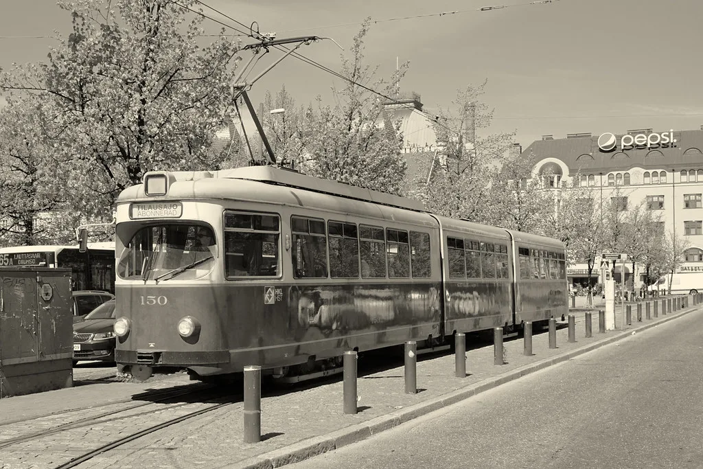A historic tram traveling along a street in a European city