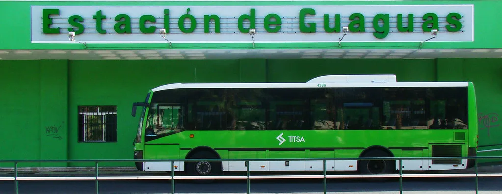 A bright green TITSA guagua bus on a street in Tenerife