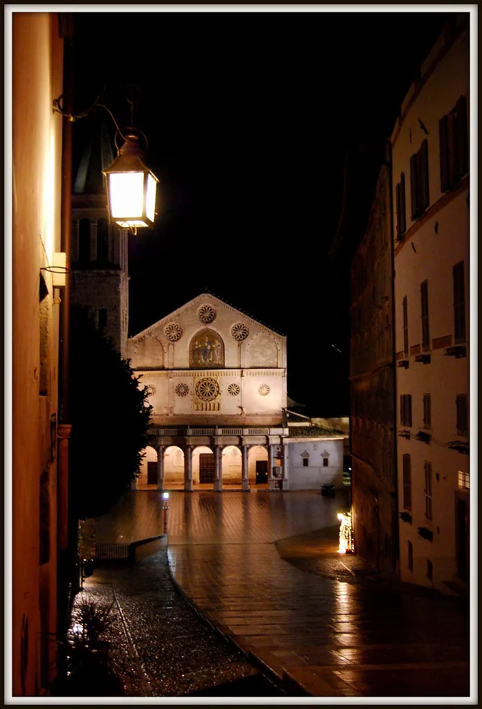 A narrow medieval street in Spoleto's historic centre lined with stone buildings and local eateries