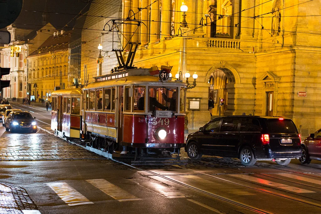 A red Prague tram passing the National Theatre in the historic city centre