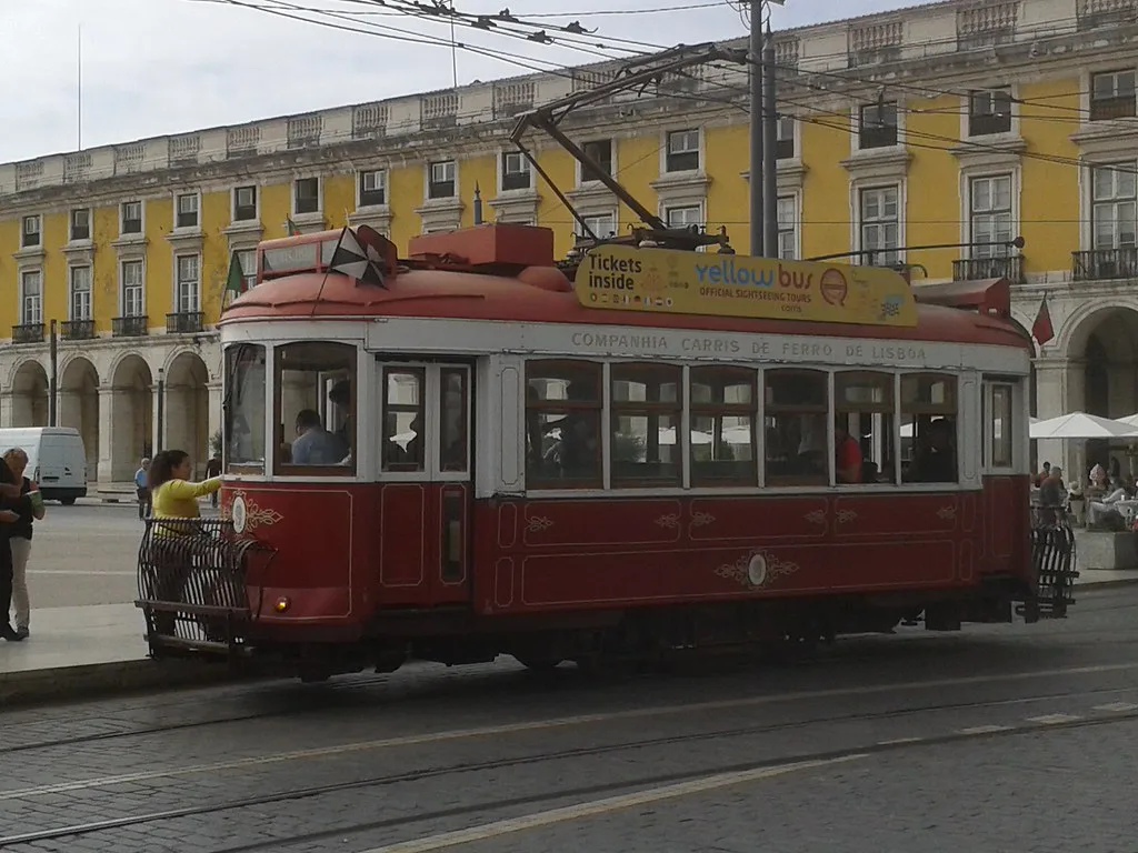 A vintage heritage tram on a city street, the kind that climbs steep European hills