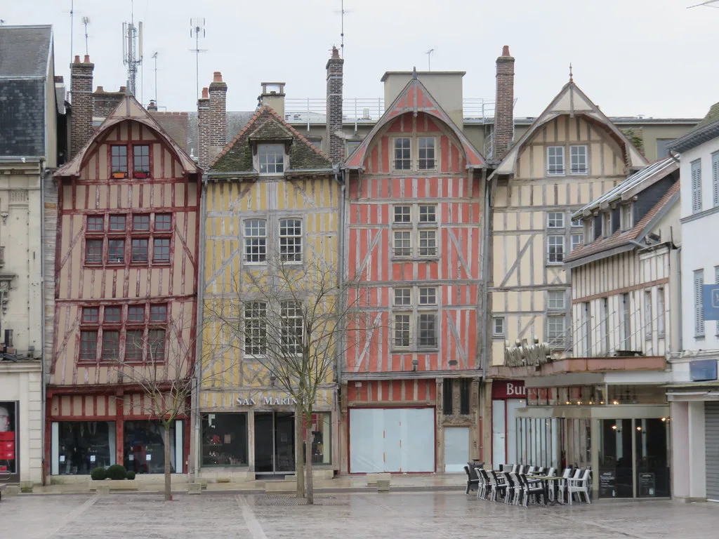 A narrow half-timbered street in central Troyes where colour-coded on-street parking zones apply